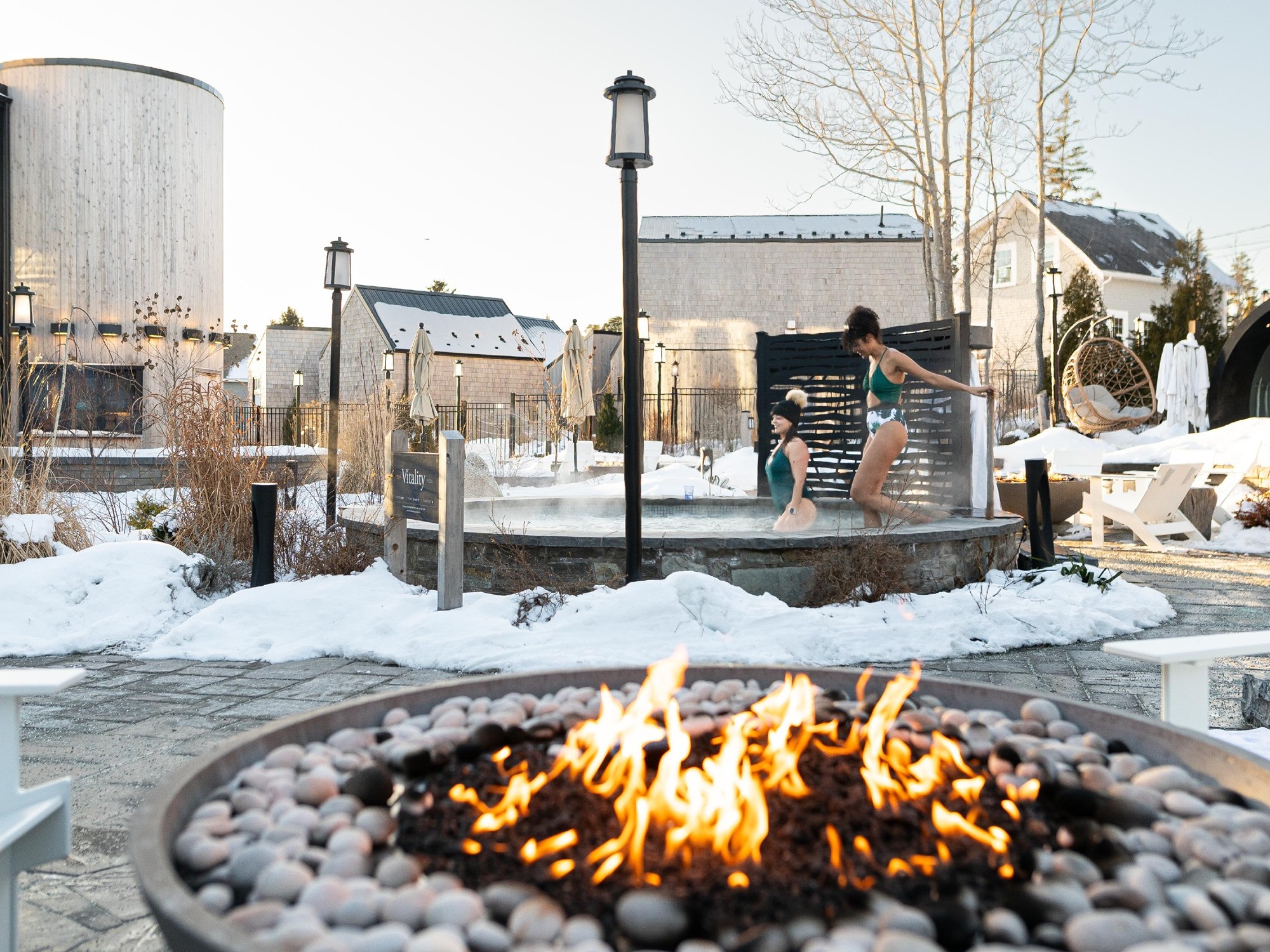 Two women enter a pool at the Hydrothermal Spa at Oceanstone Resort in Nova Scotia during winter.