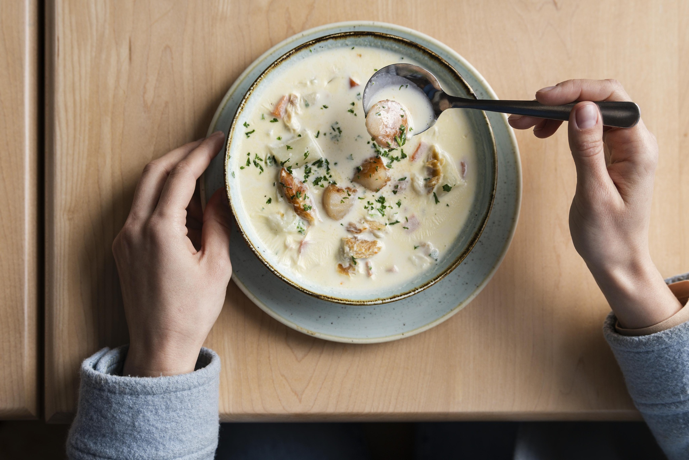 An overhead view of a bowl of chowder with scallops from the Salt Shaker Deli in Lunenburg, Nova Scotia