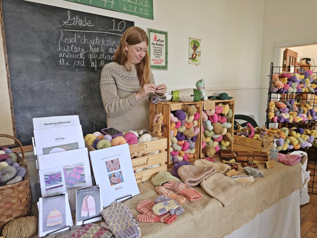A lady showcases her work and various fibres at the Memory Lane Fibre Arts Festival in Nova Scotia