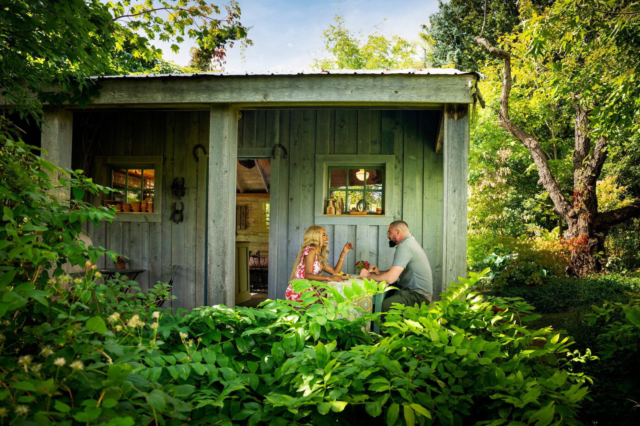 A couple sitting at a small table in a garden.