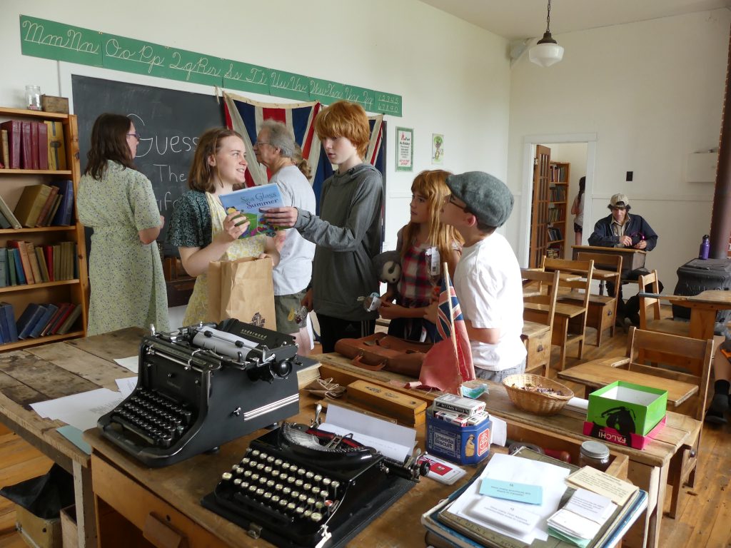 AN interior view of some kids inside the schoolhouse with type writer at the Dominion Day “Old Time” Village Fair at Memory Lane in Nova Scotia