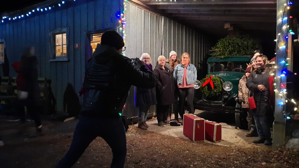 A group of people pose for a picture in front of a Christmas truck at the Memory Lane Christmas Walk in Nova Scotia