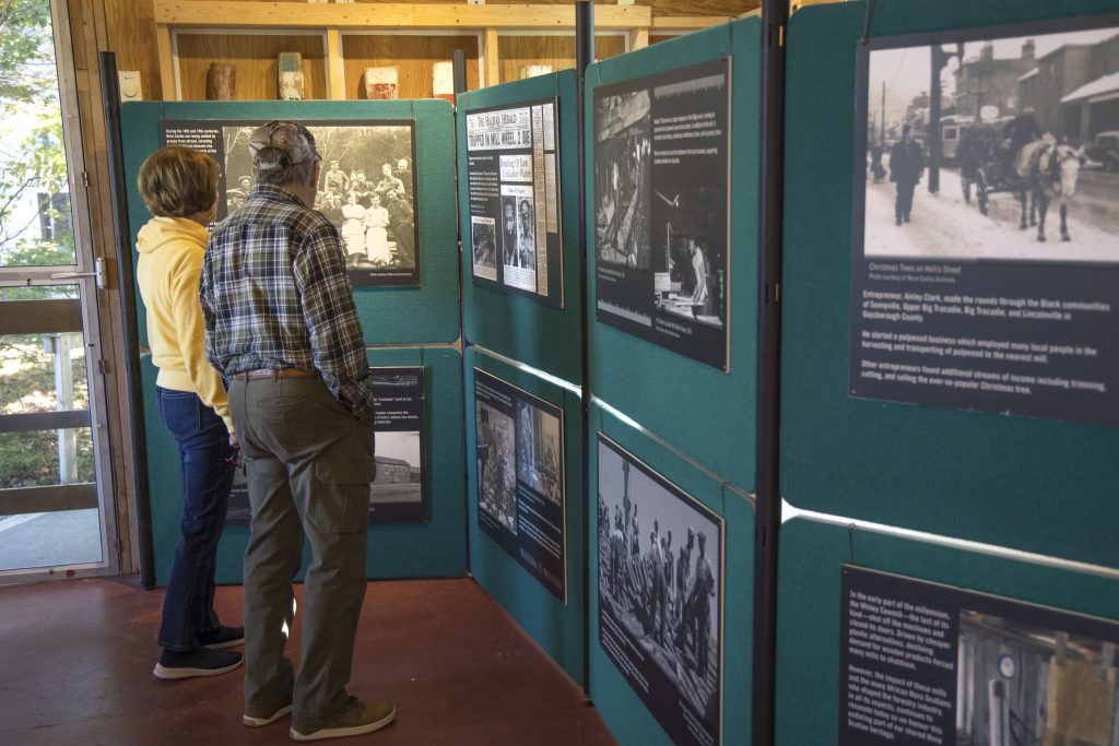 A man reads a wall of information with photos during the Nova Scotia Forest Festival at Memory Lane in Nova Scotia