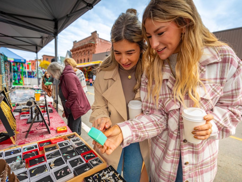 Two women shop during a market at a fall festival in Amherst, Nova Scotia