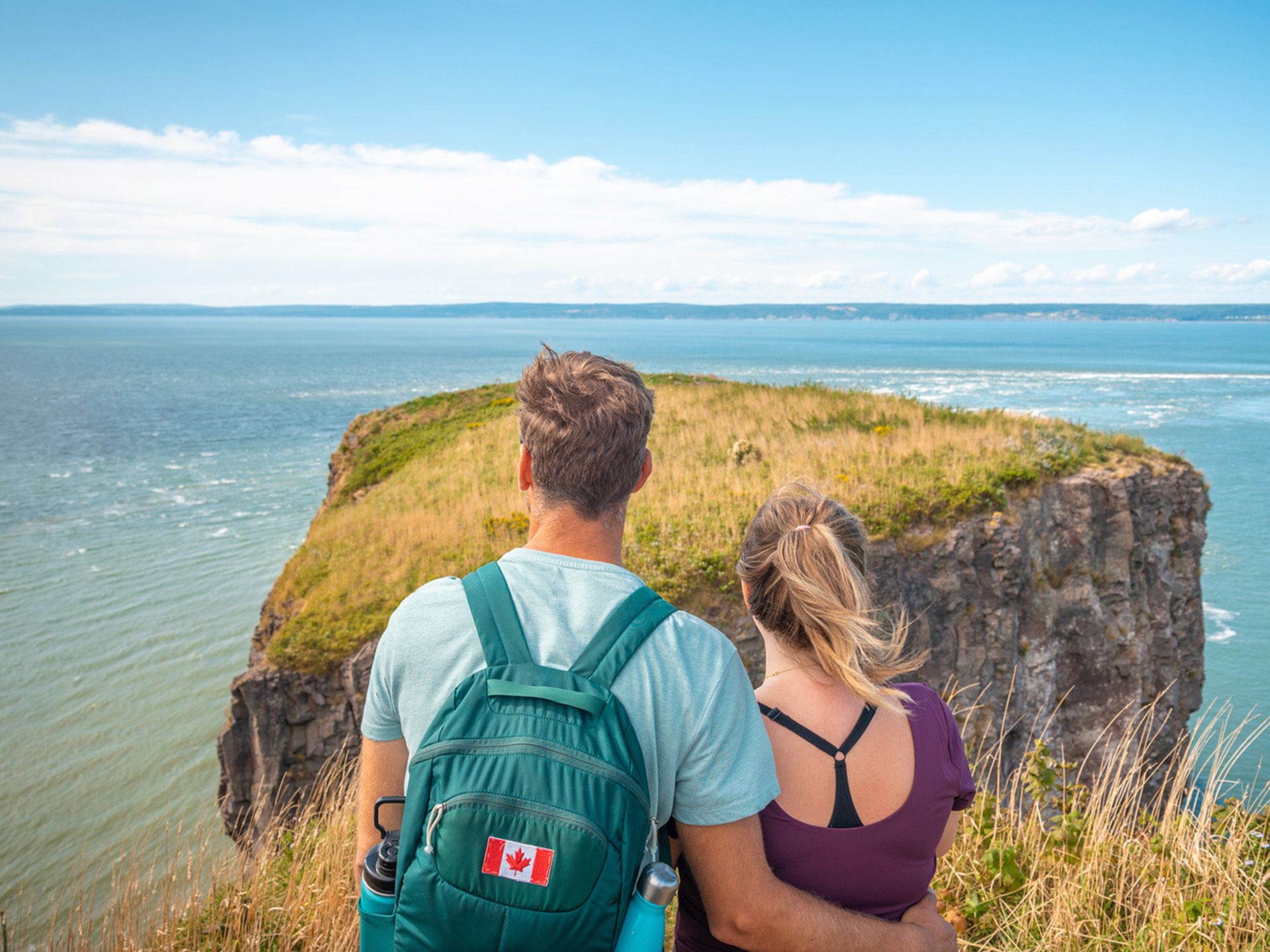 Couple hiking Cape Split Provincial Park on a bright summer day