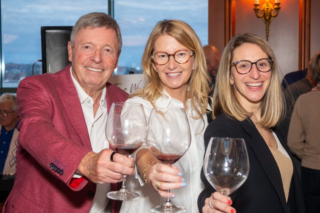 Three people cheers a glass of wine at the Rare & Fine Wine Tasting in Halifax, Nova Scotia
