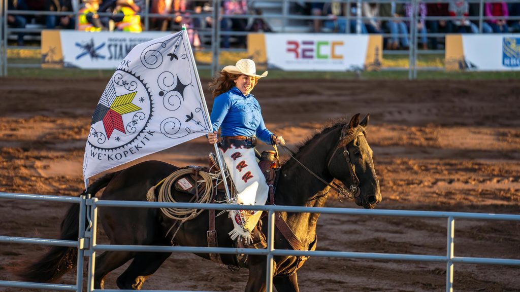 A rider on a horse carries a flag during the Nova Scotia Stampede