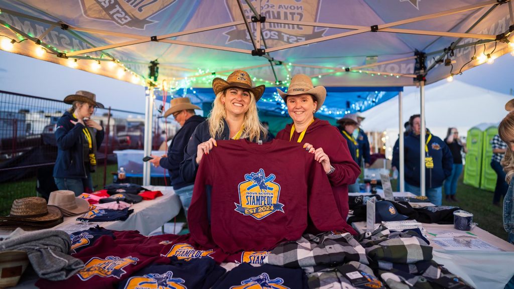 Two people display the swag available at the Nova Scotia Stampede