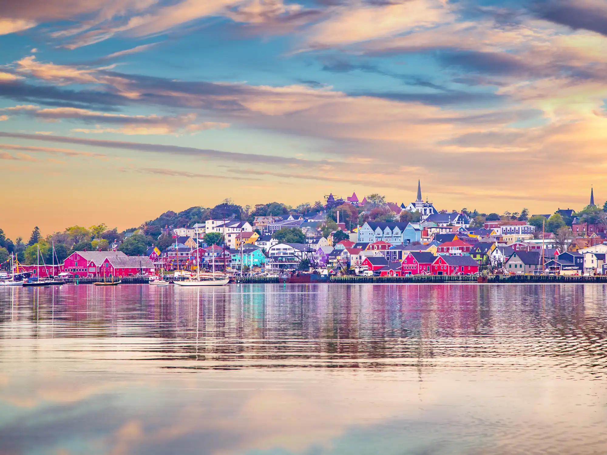 View of the Lunenburg Waterfront with colorful buildings and sailboats in the harbor.