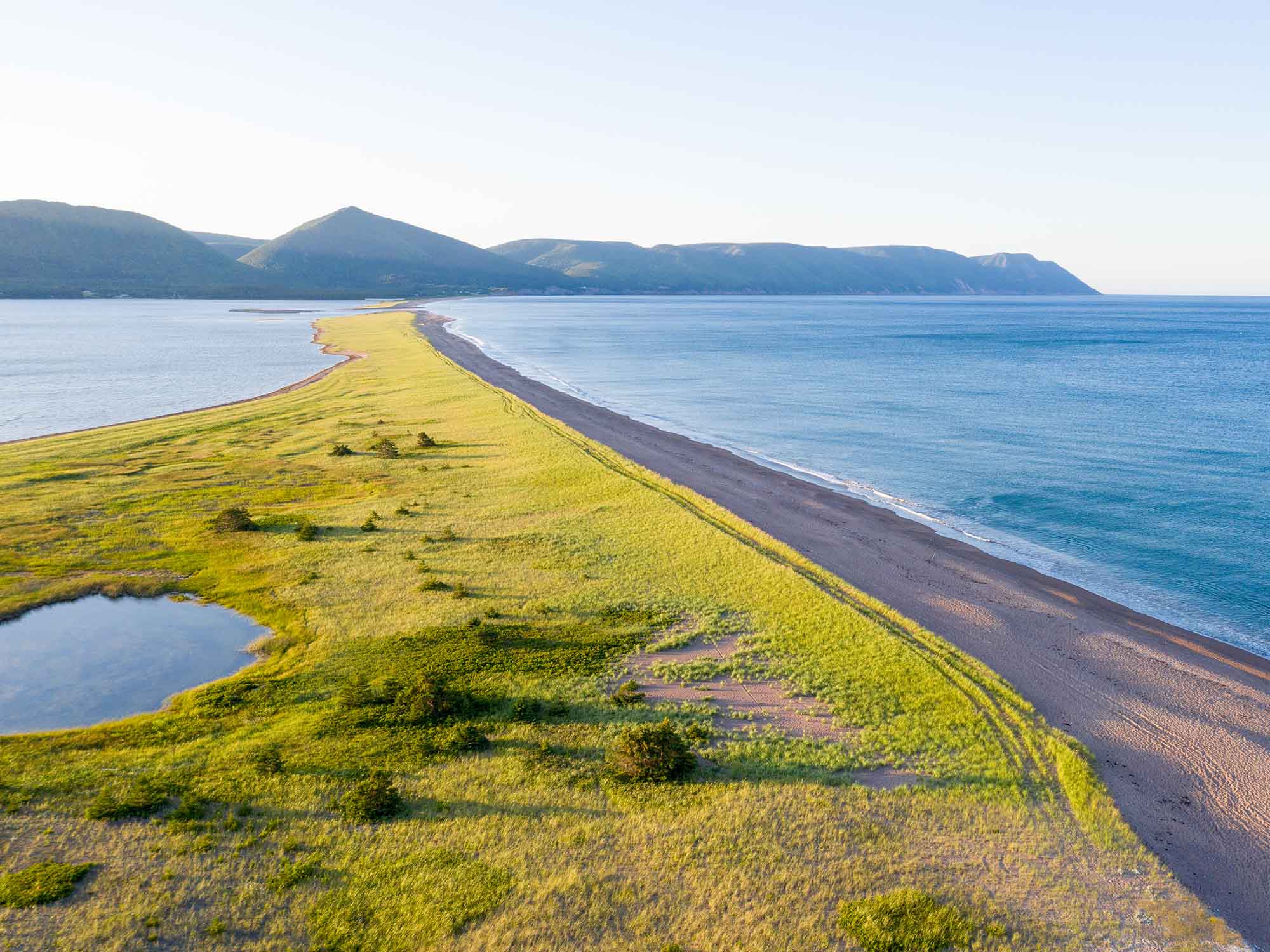 Drone view over the beach at Aspy Bay from Dingwall with the Cape Breton Highlands mountain range in the distance just off the Cabot Trail in Cape Breton, Nova Scotia