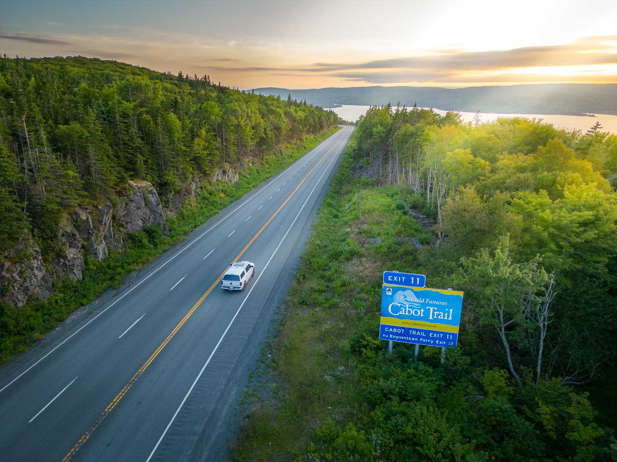 Car travelling Highway 105 towards the Englishtown Exit where they can take the Englishtown Ferry to catch the Cabot Trail in Cape Breton Nova Scotia