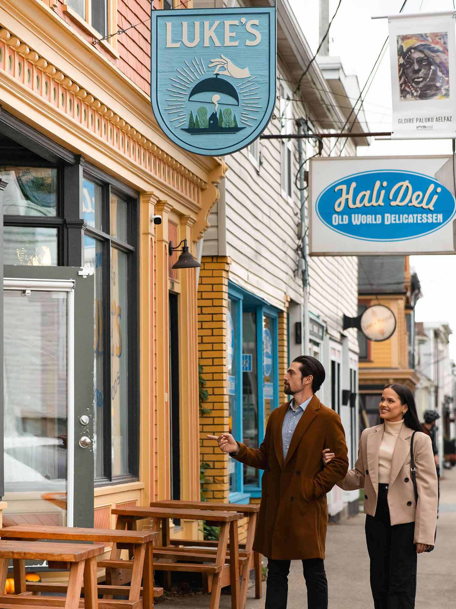 Two people walking towards Brewery Park Hotel on Agricola St, near Hali Deli which was used as Shandon's Restaurant on Sullivan's Crossing which is filmed entirely in Nova Scotia.