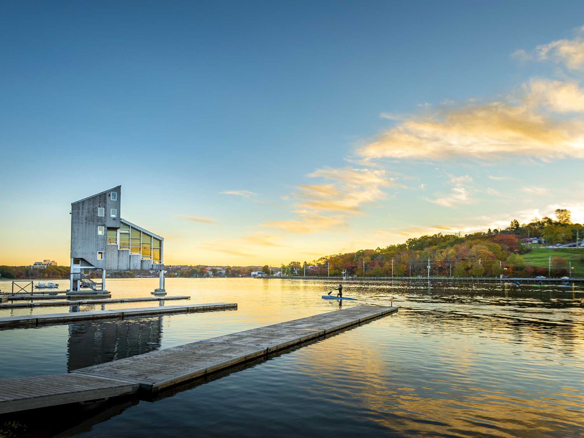 Sunrise over Lake Banook as a paddler glides through the stillness of the lake, located across Halifax Harbour from Halifax in Dartmouth, Nova Scotia.