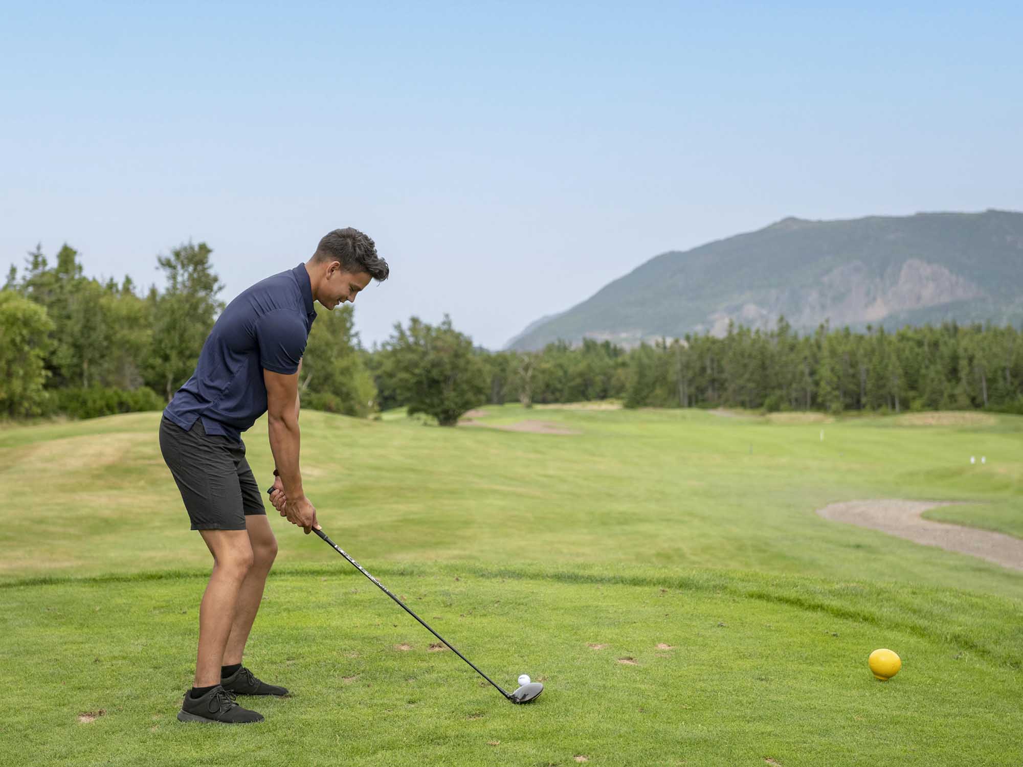 A person is preparing to tee off at Le Portage Golf Course in Cheticamp in Cape Breton, Nova Scotia