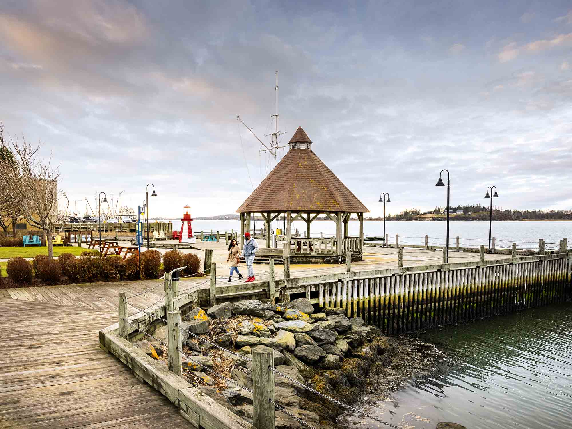 Two people strolling the quiet Yarmouth waterfront on a fall afternoon in Yarmouth, Nova Scotia