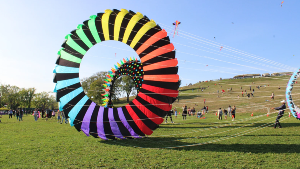 A large circular rainbow kite takes off at the Garrison Grounds as part of the East Coast Kite Festival
