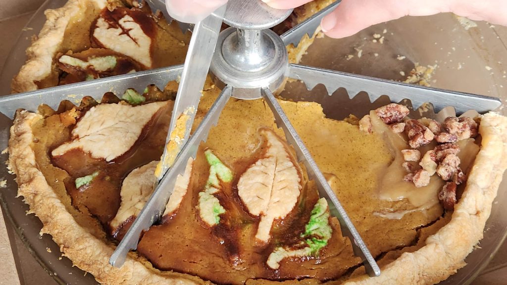 A close up view of someone cutting a pumpkin pie at the HarvFest on the Harbour event in Pictou Nova Scotia