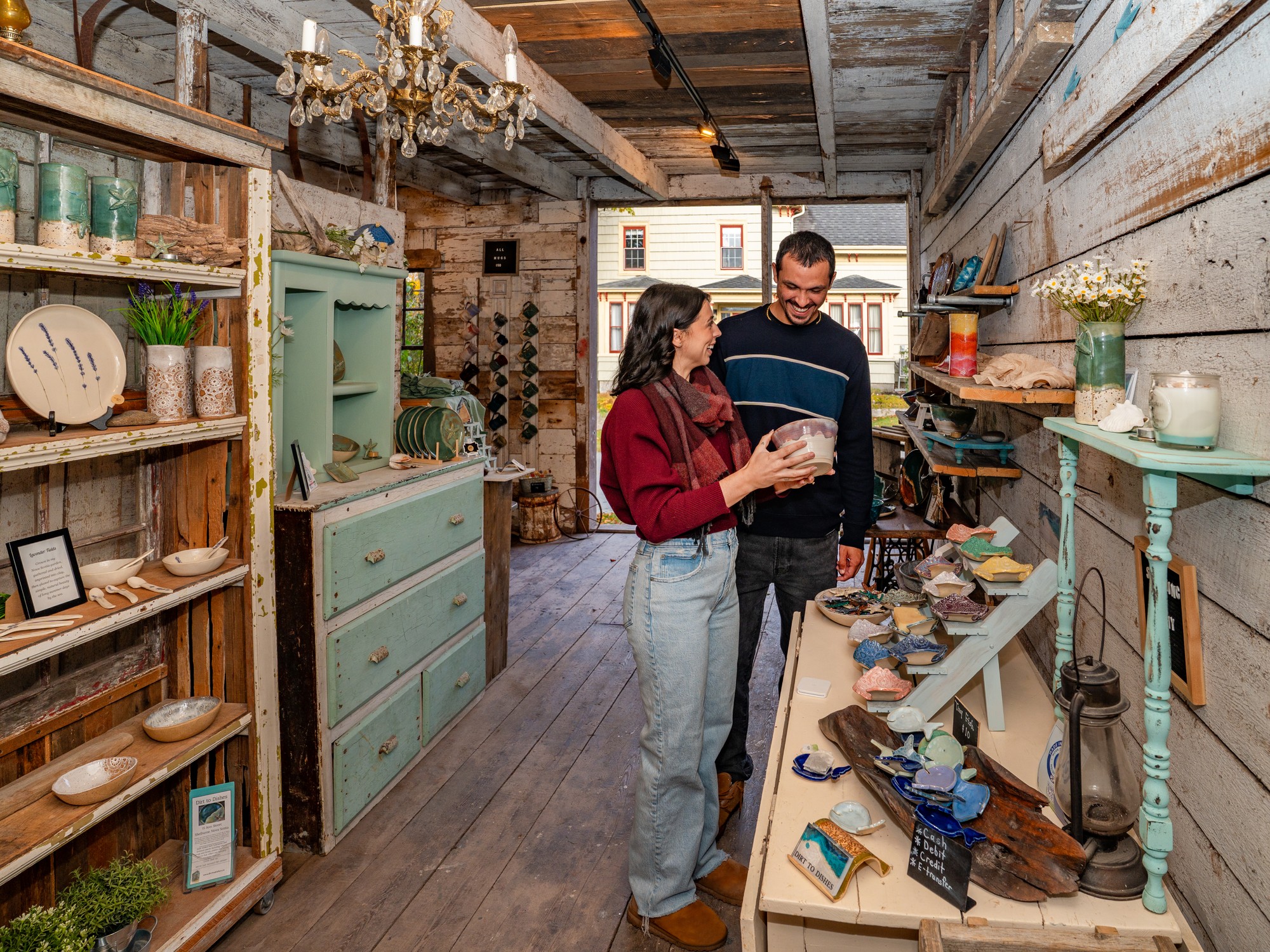 Two people shop for pottery at From Dirt to Dishes in Shelburne, Nova Scotia