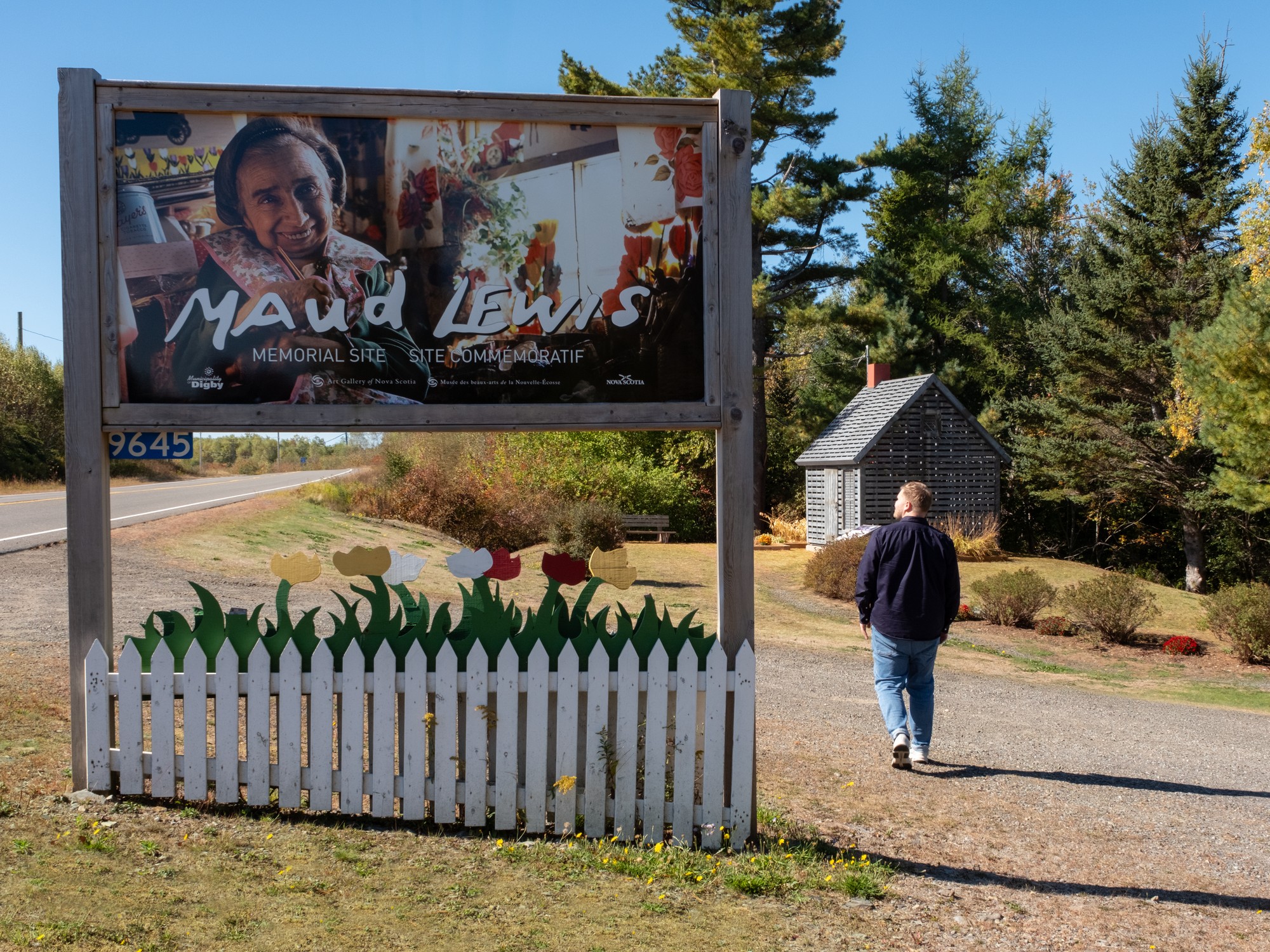 A man walks past the entrance to Maud Lewis Park in Nova Scotia