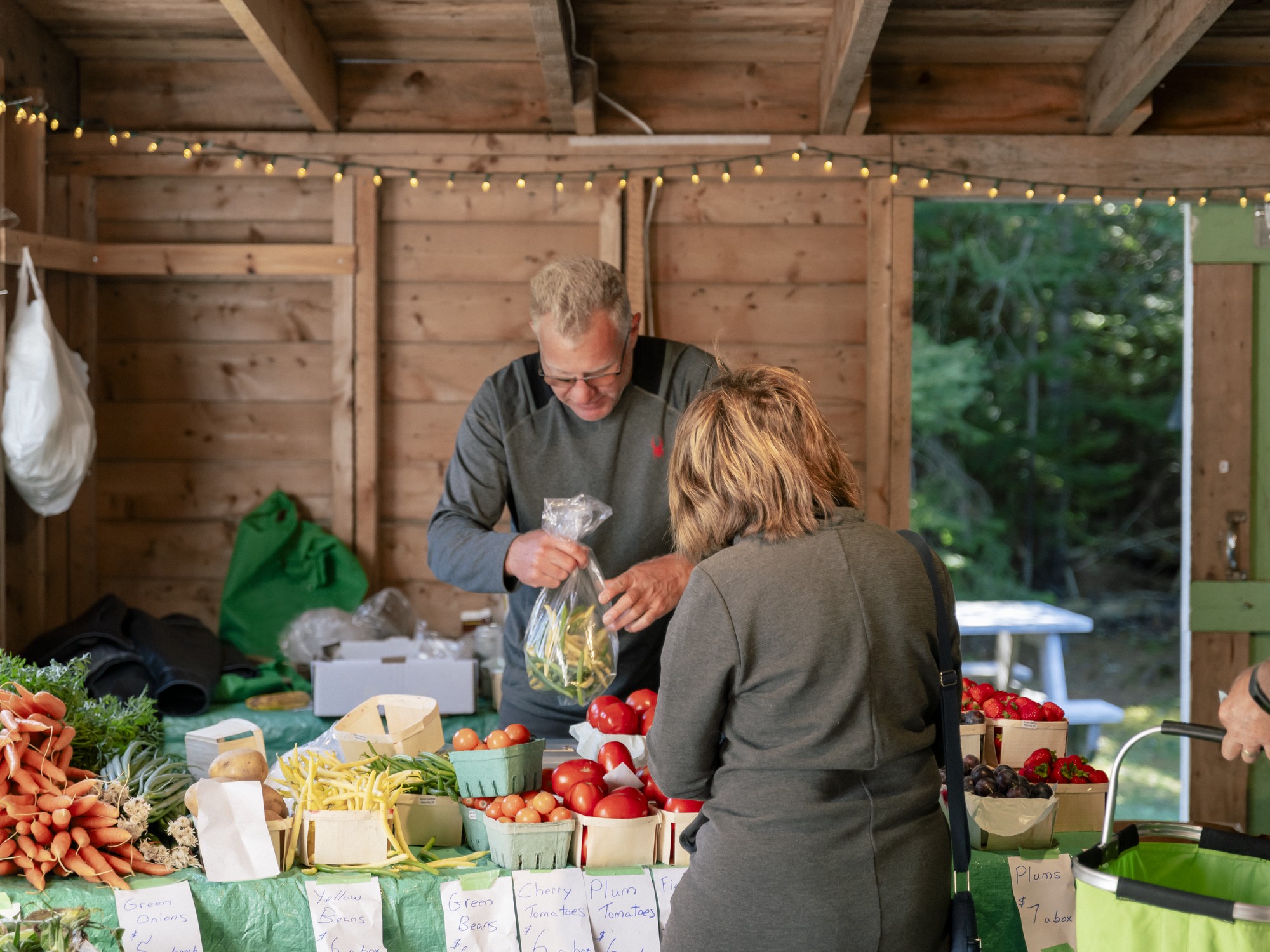 A vendor puts vegetables in a bag for a customer at the Hubbards Barn Farmers Market in Nova Scotia