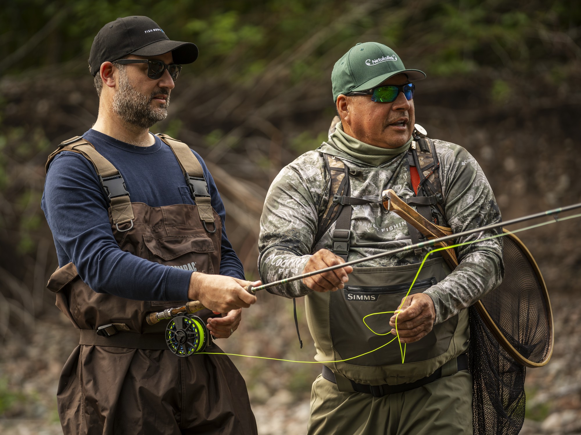 A guide and a man are fly fishing in Cape Breton, Nova Scotia