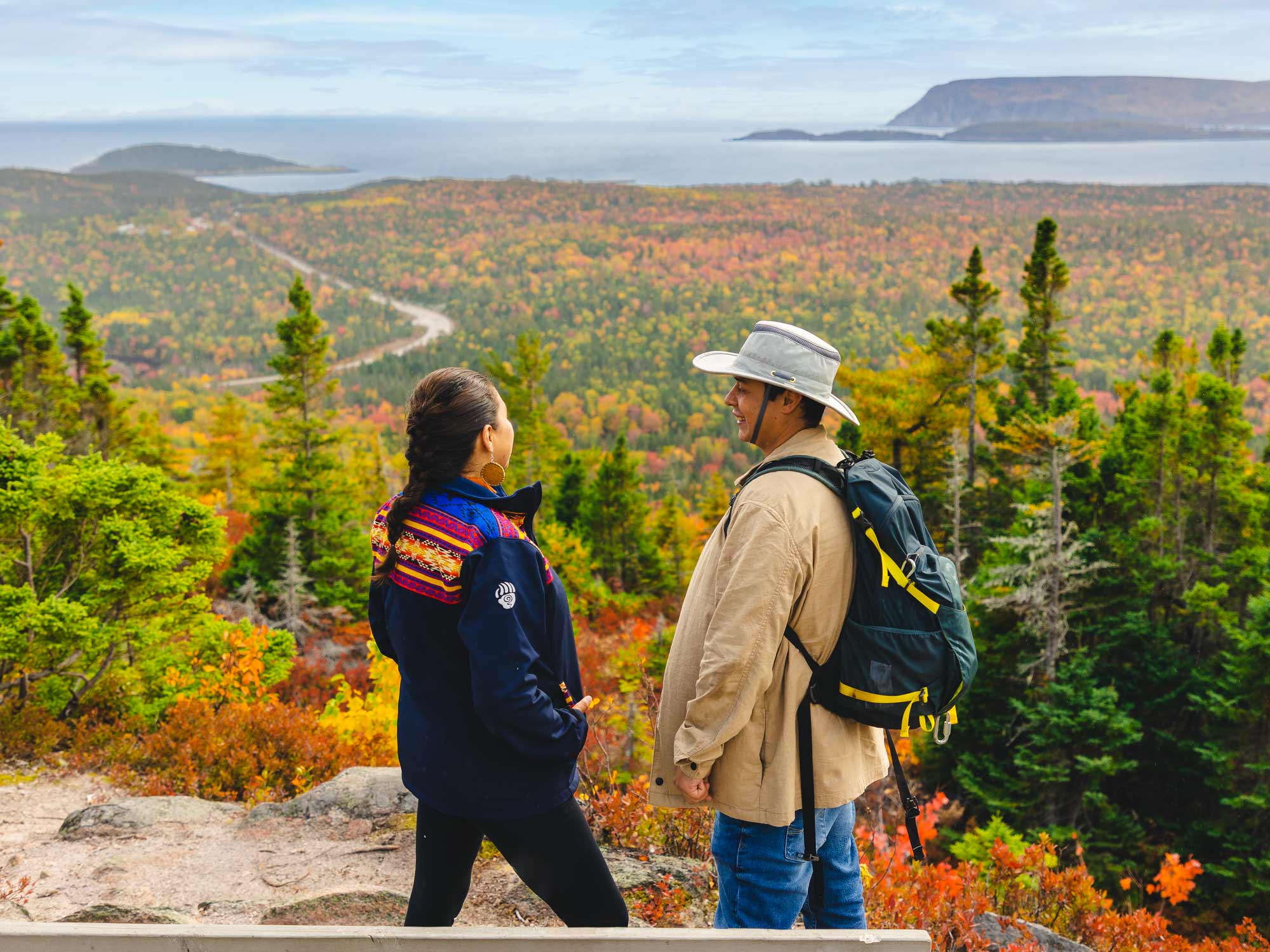 Two people checking out the incredible views from the Broad Cove Trail in autumn in the Cape Breton Highlands National Park in Nova Scotia.