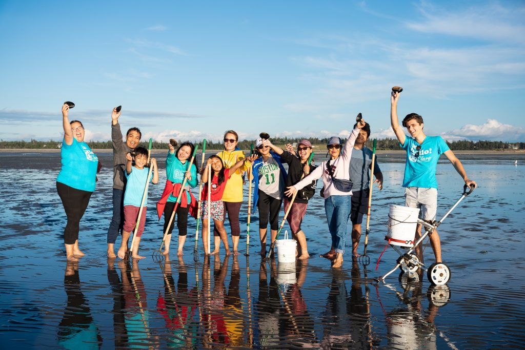 A group of people dig clams during the Festival de Coques (Clam Festival) in Clare, Nova Scotia