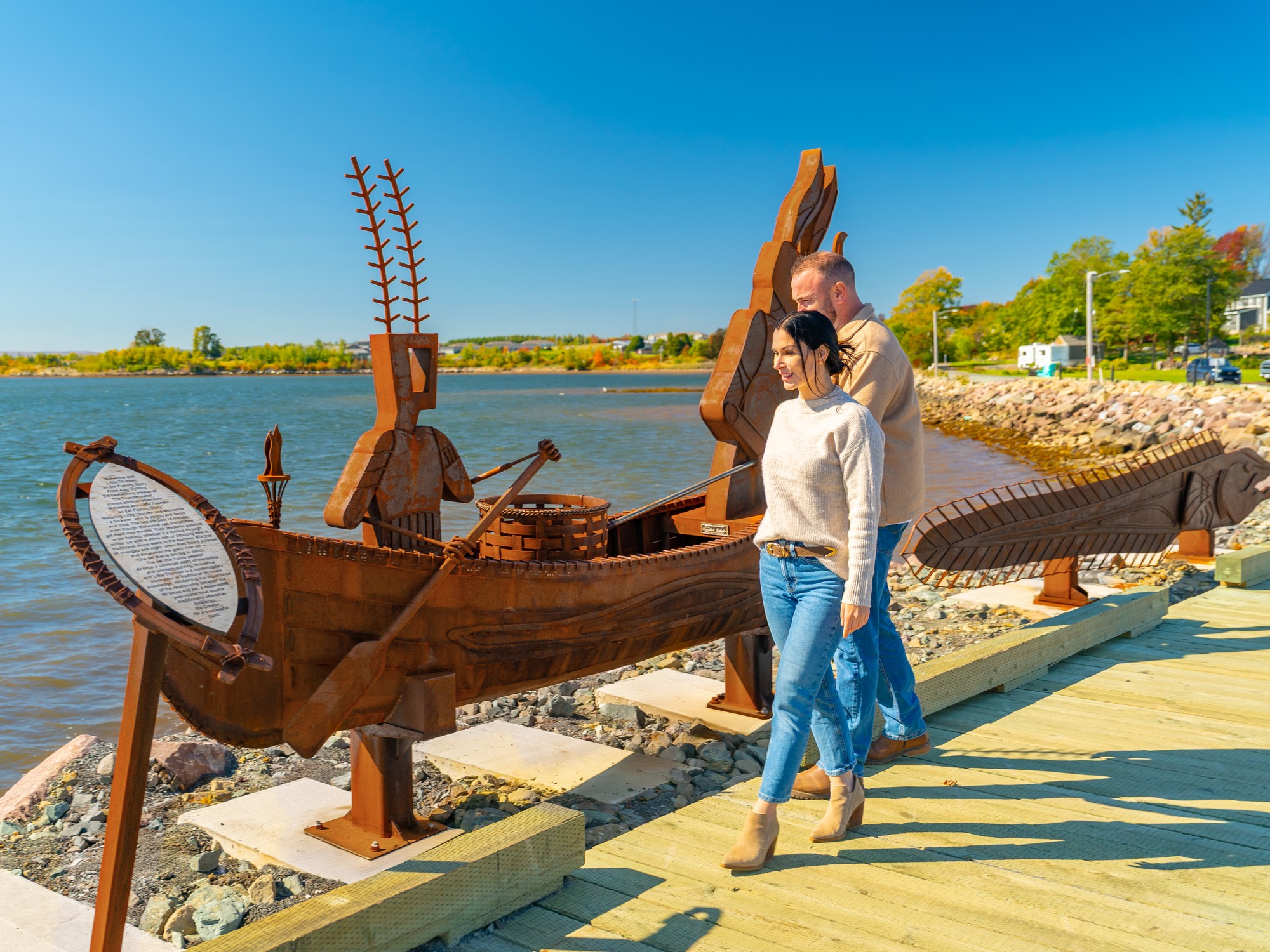 Two people look at a sculpture along the Jitney Trail on the Pictou Waterfront in Nova Scotia.