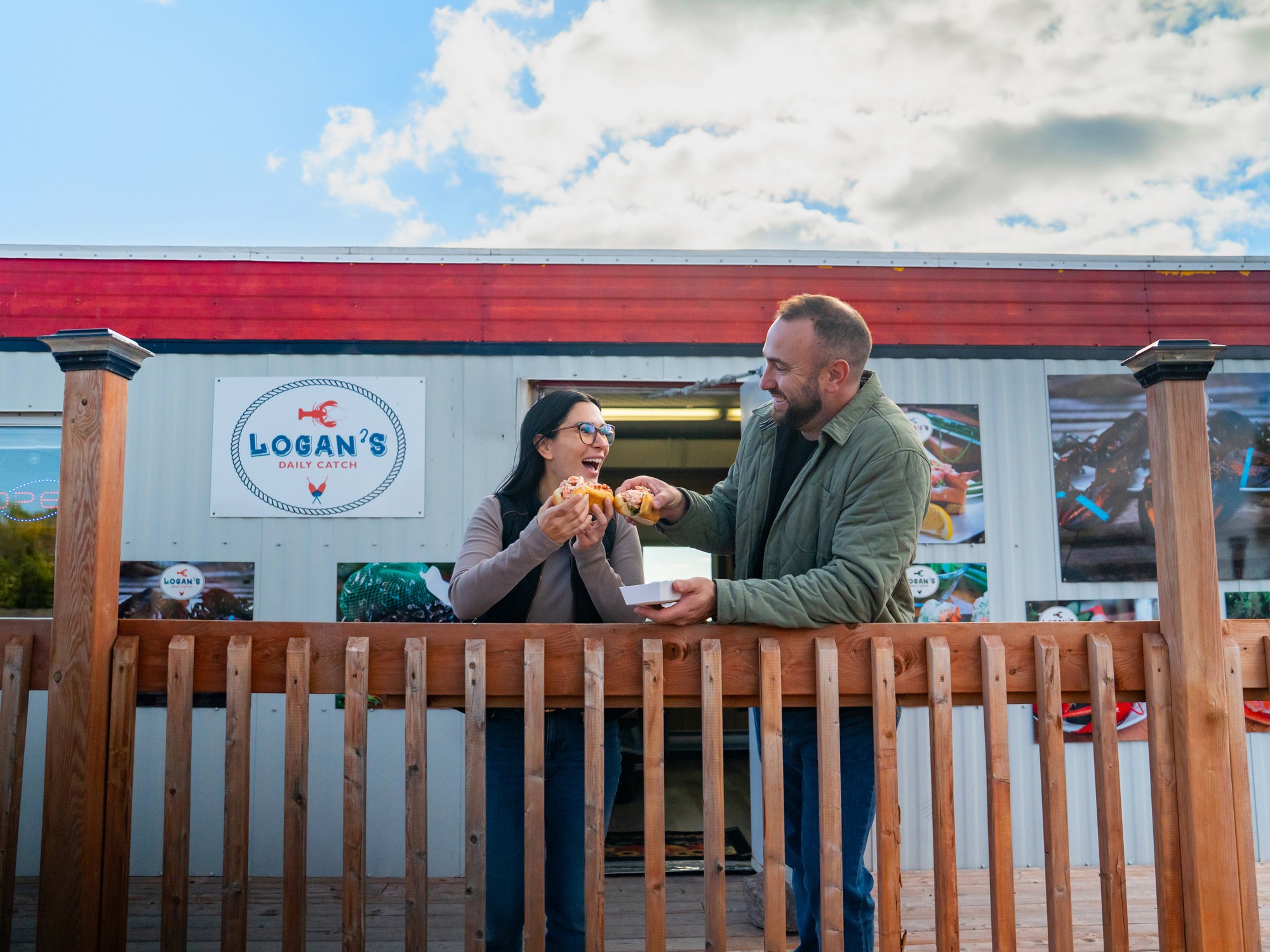 Two people stand outside Logan's Daily Catch near Pictou, Nova Scotia
