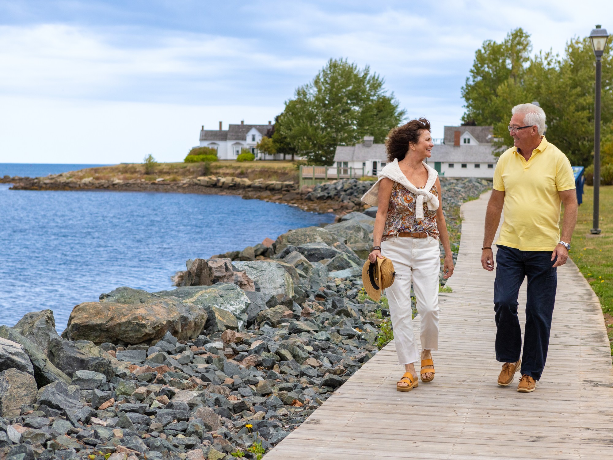 Two people walk along the waterfront in Pugwash, Nova Scotia