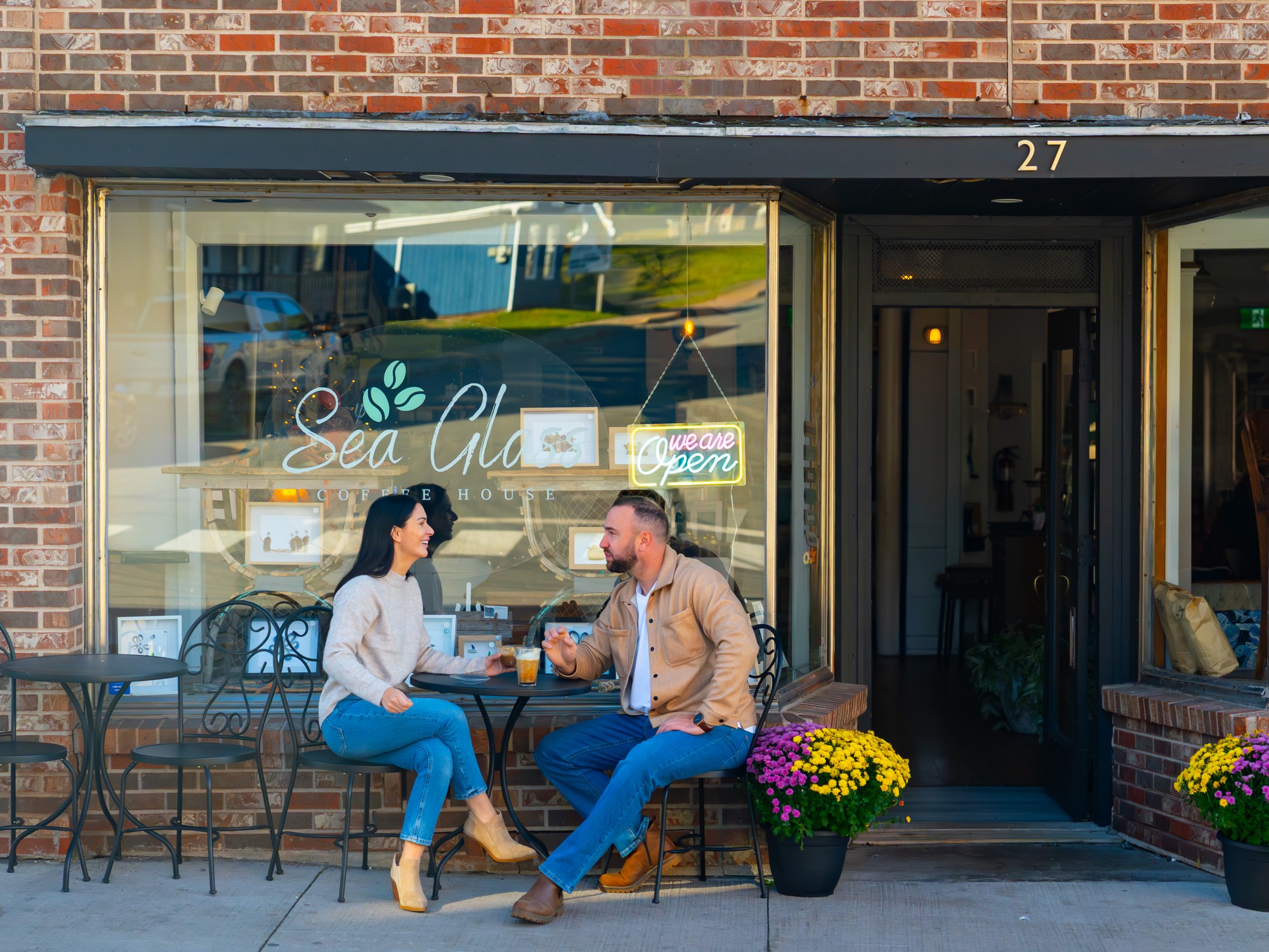 Two people sit at a table outside of Sea Glass Coffee House in Pictou, Nova Scotia
