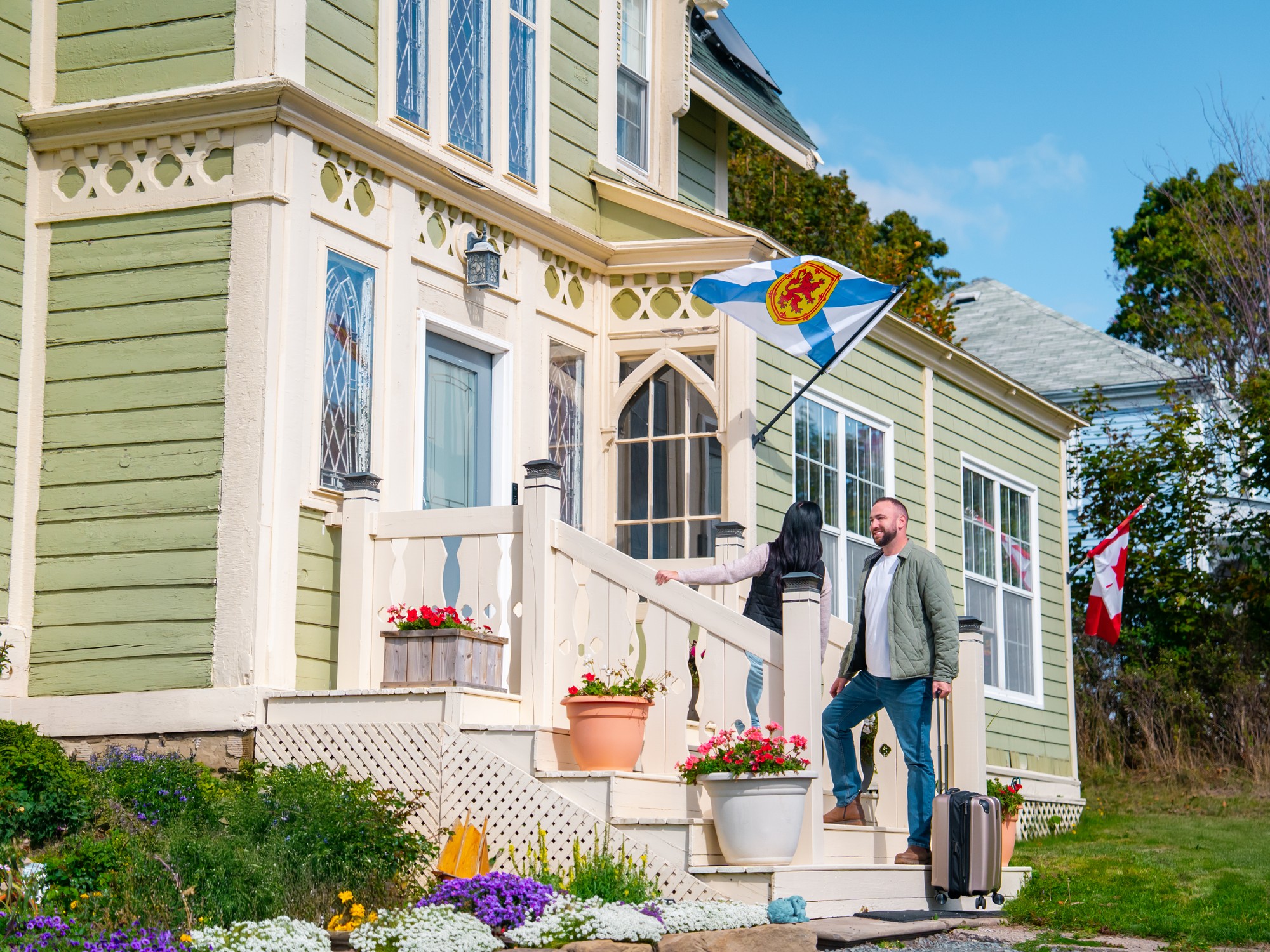 Two pepole with their suitcase enter the Seabank House in Pictou, Nova Scotia