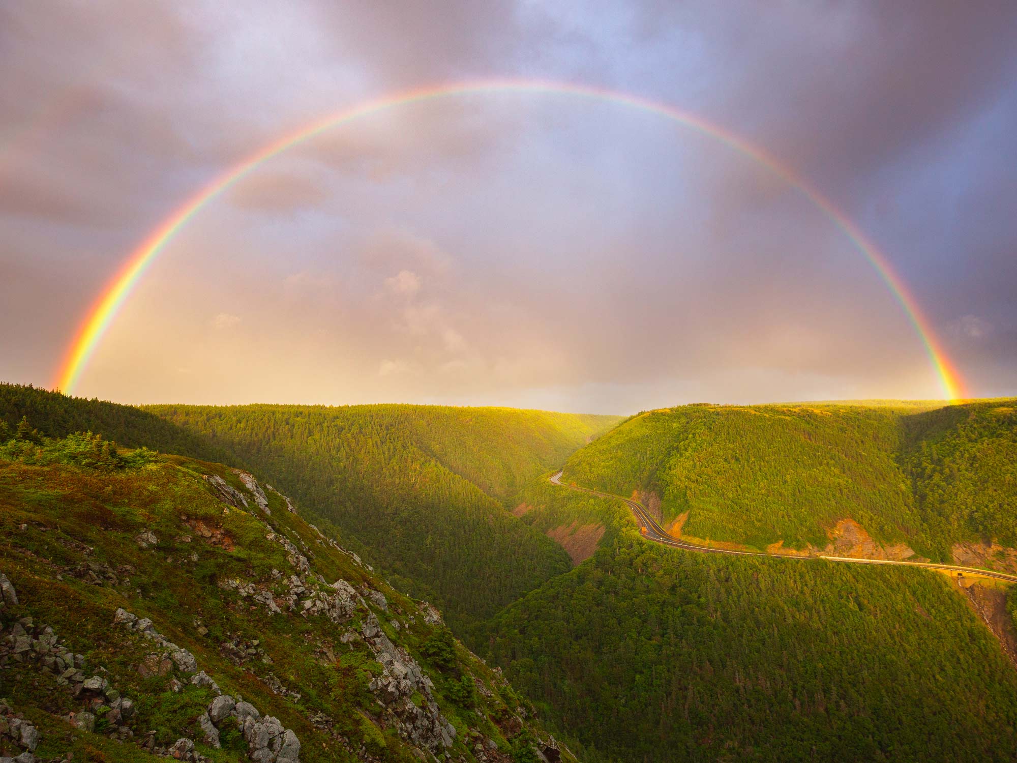 A rainbow stretches over the Cabot Trail towards the Skyline Trail after a rainfall from the end of the skyline Trail in Cape Breton, Nova Scotia.