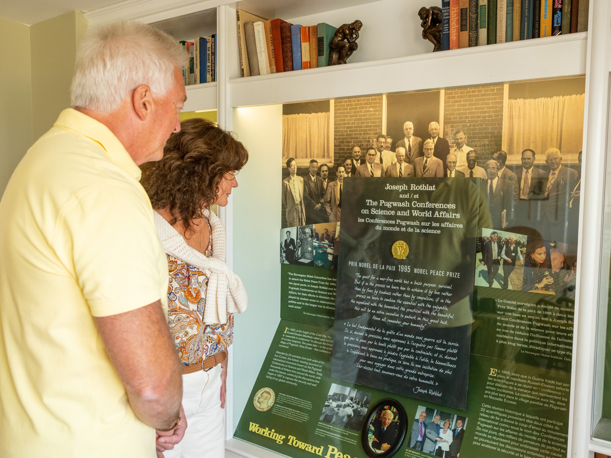 Two people look at an exhibit behind a glass case at Thinkers' Lodge in Pugwash, Nova Scotia