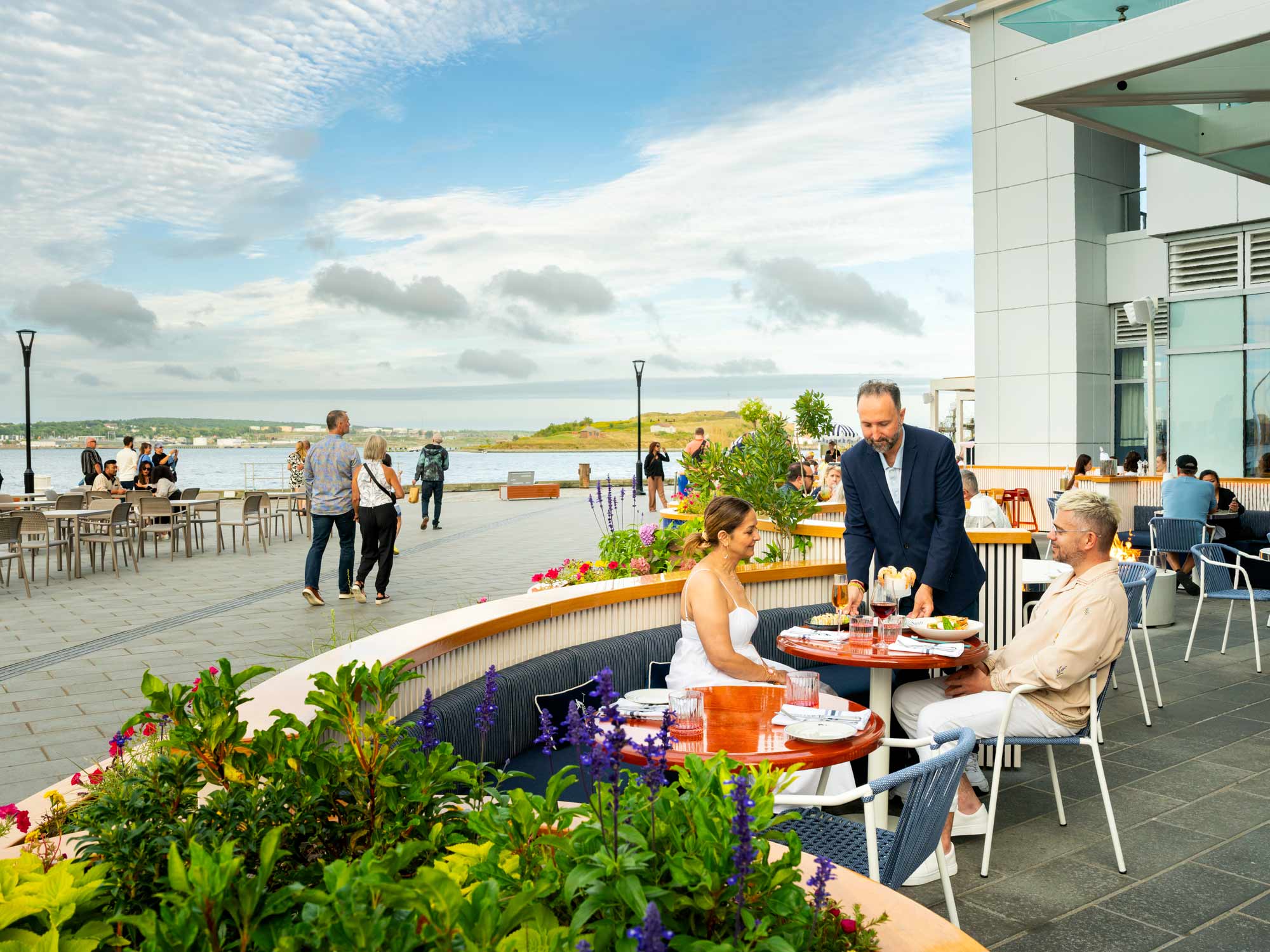 Two people dining on the patio of Water Polo, one of the newest restaurants on the Halifax Boardwalk in Nova Scotia