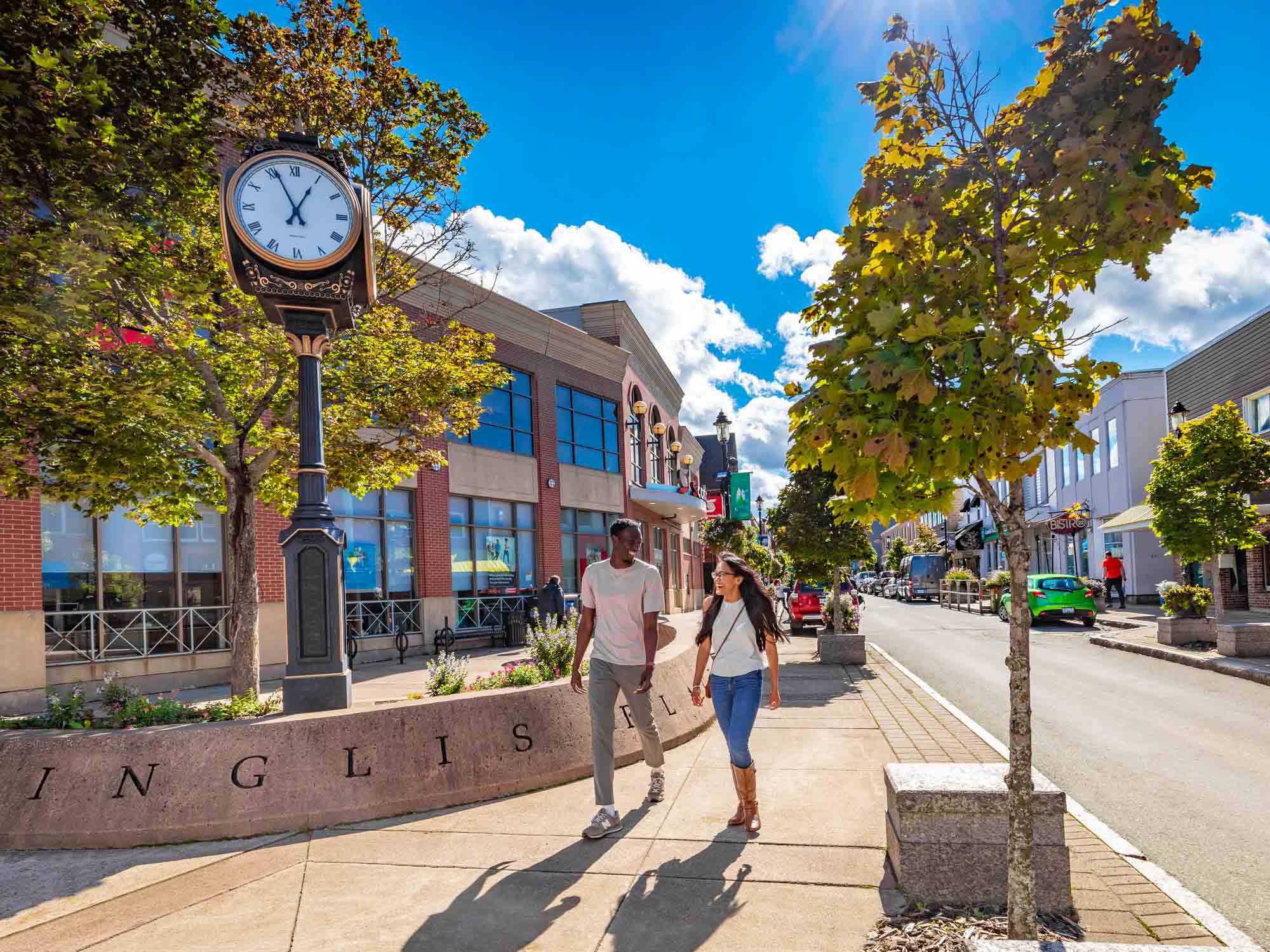 Two people laughing together as they walk around downtown Truro, Nova Scotia on a warm, sunny summer day.