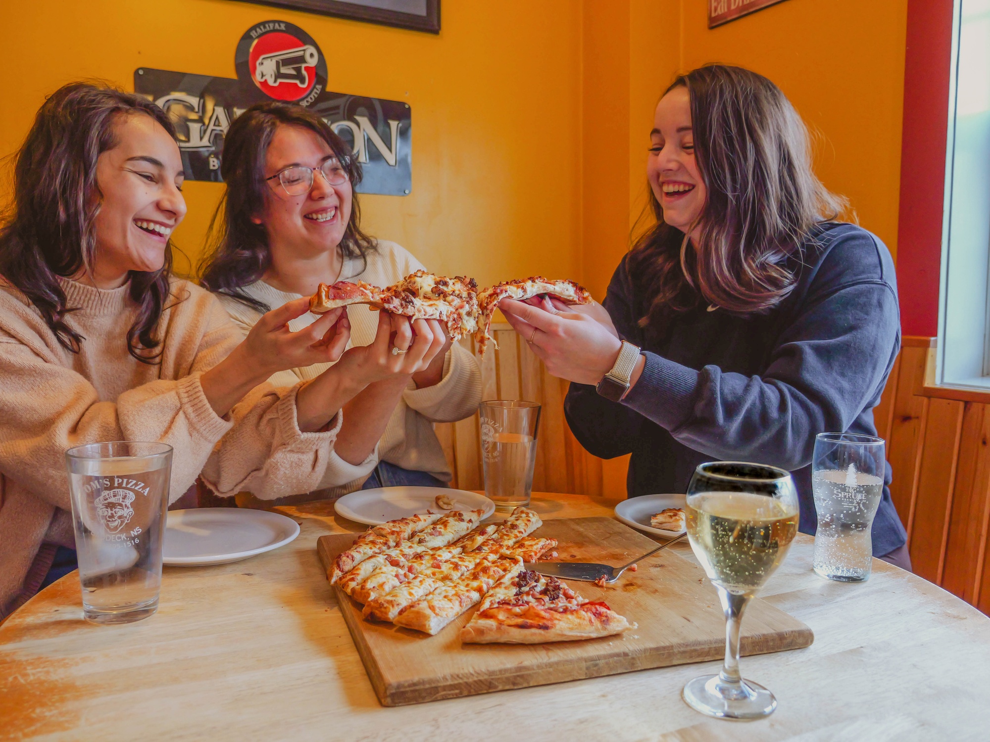 Group of people enjoying pizza & drinks