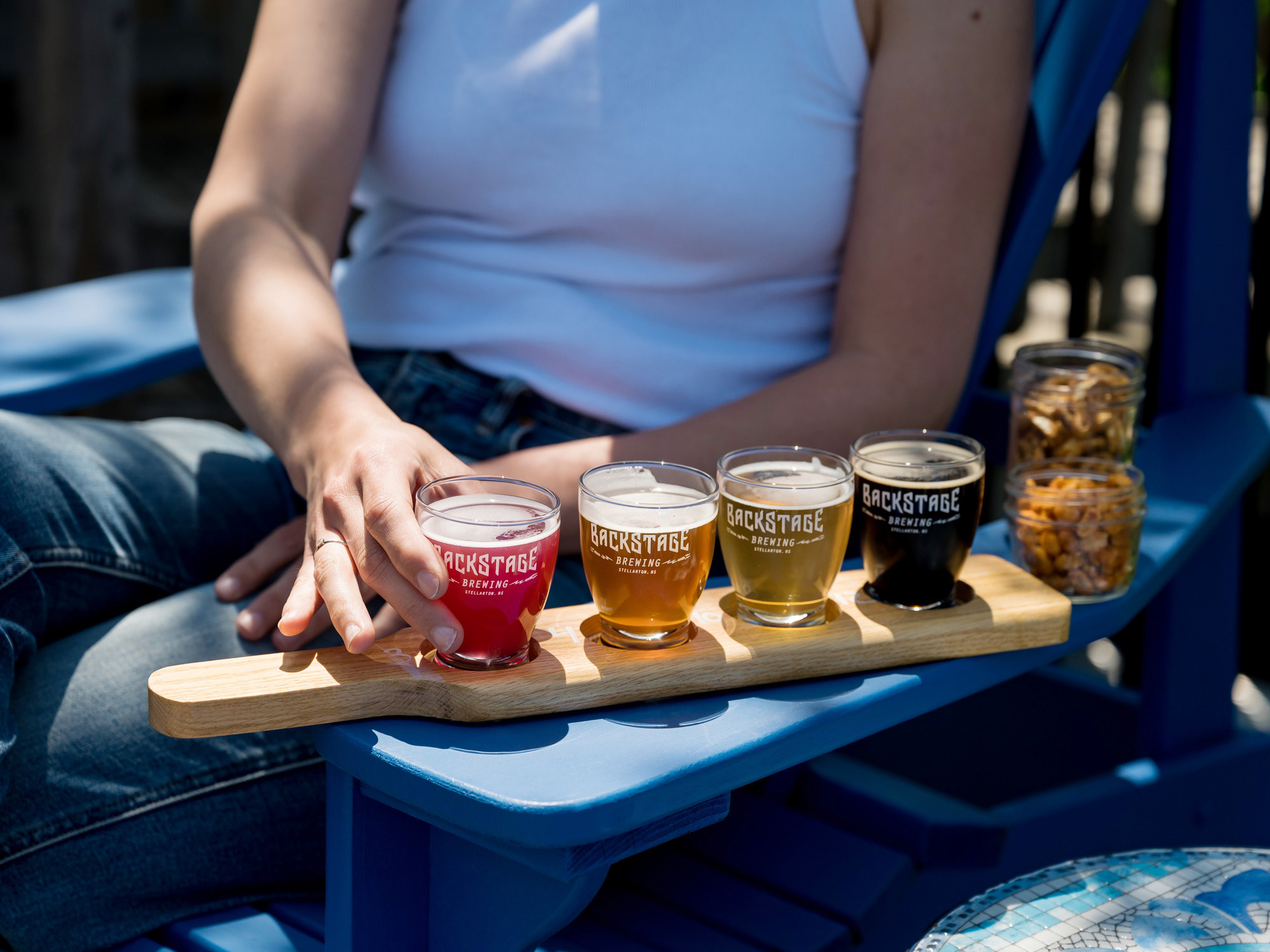 Flight of beer sitting on a sunny adirondack chair