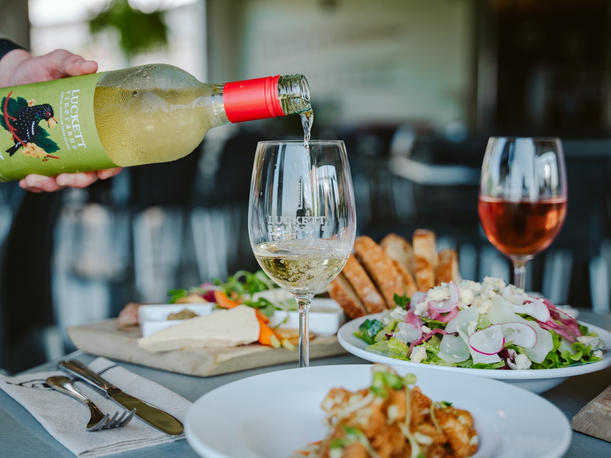 Wine being poured into a glass on a patio