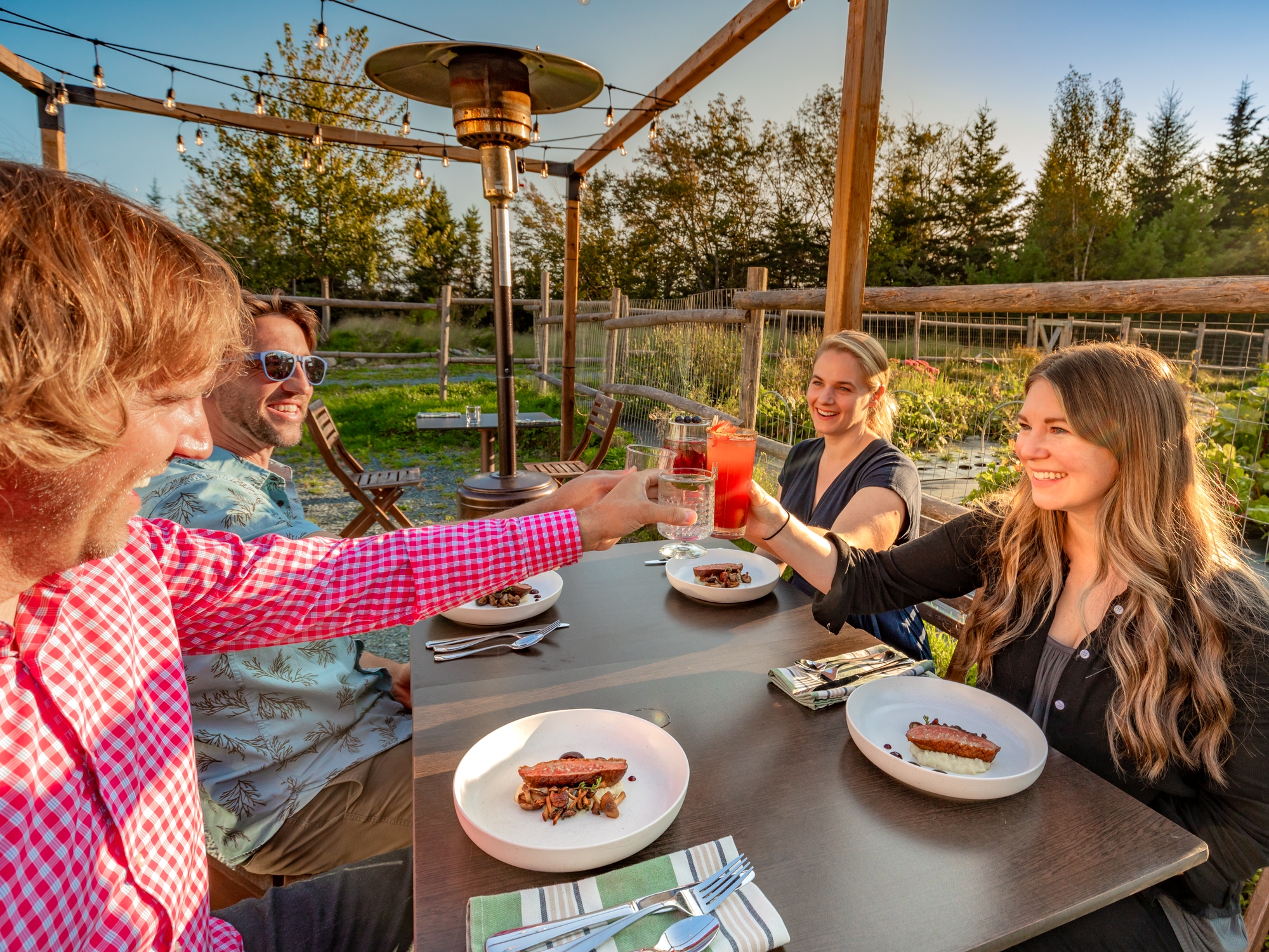 People on a patio surrounded by a garden