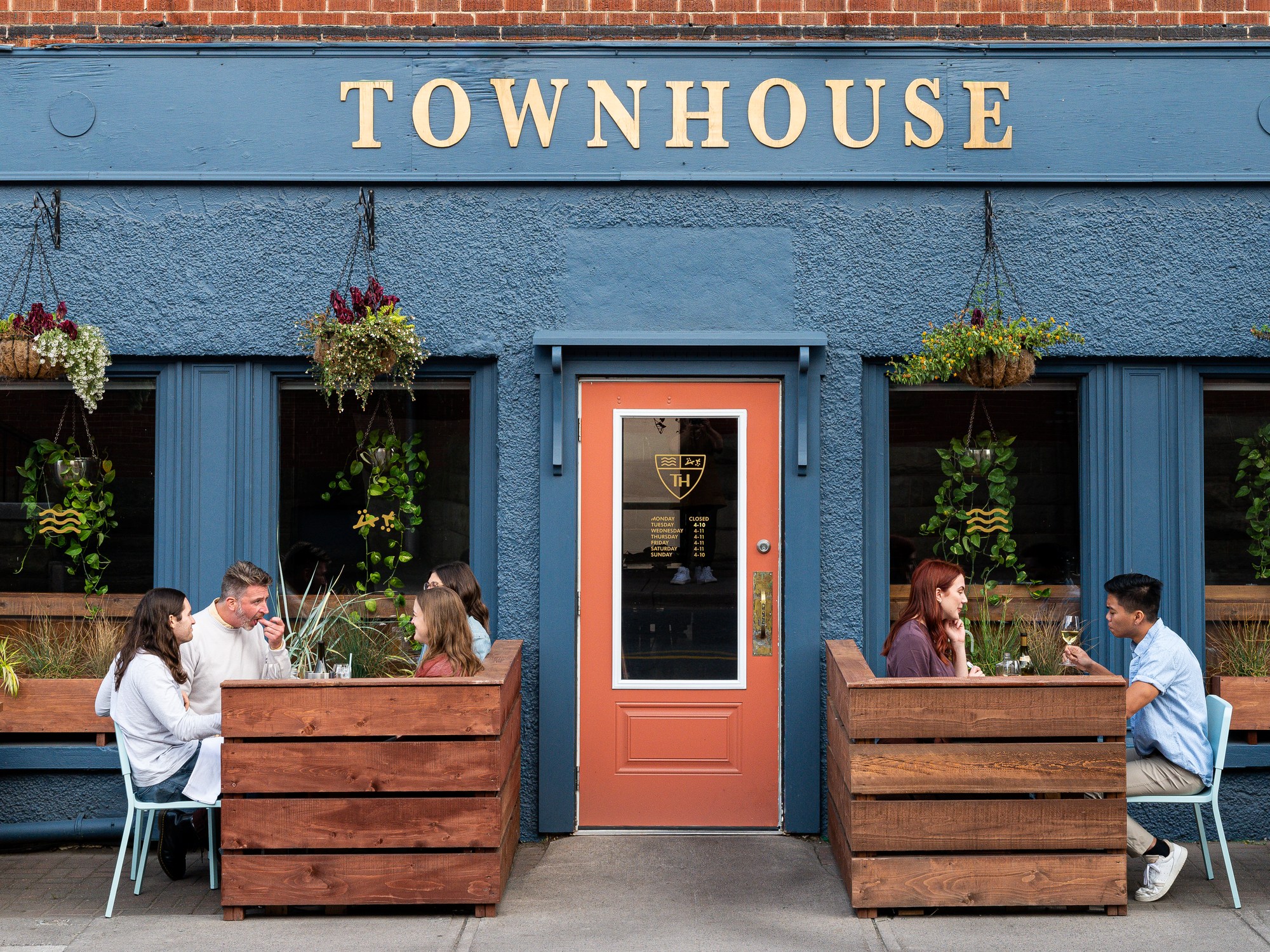 Front of a colourful restaurant with tables on each side of the door