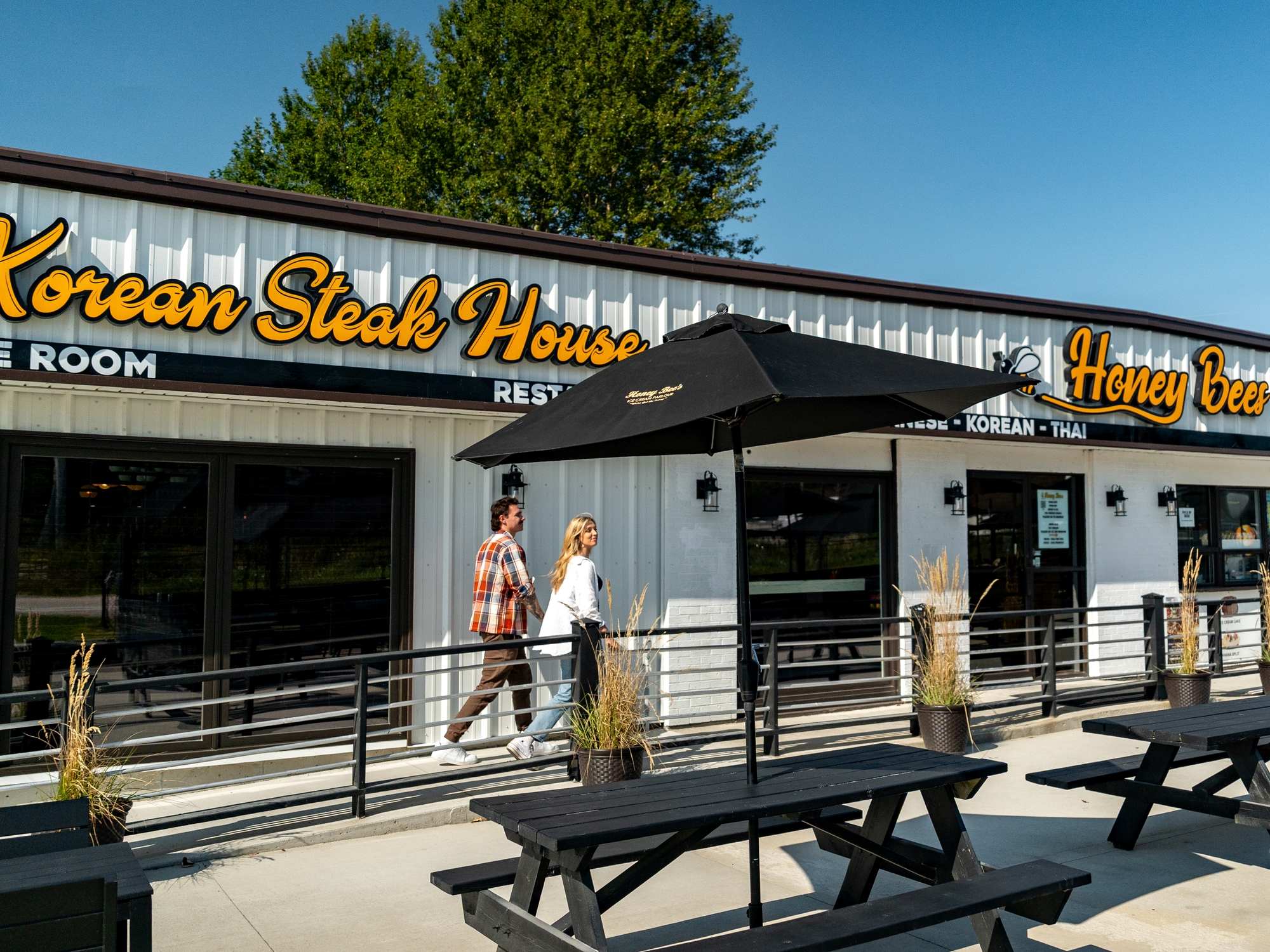 Couple walking past a patio to the entrance of a restaurant