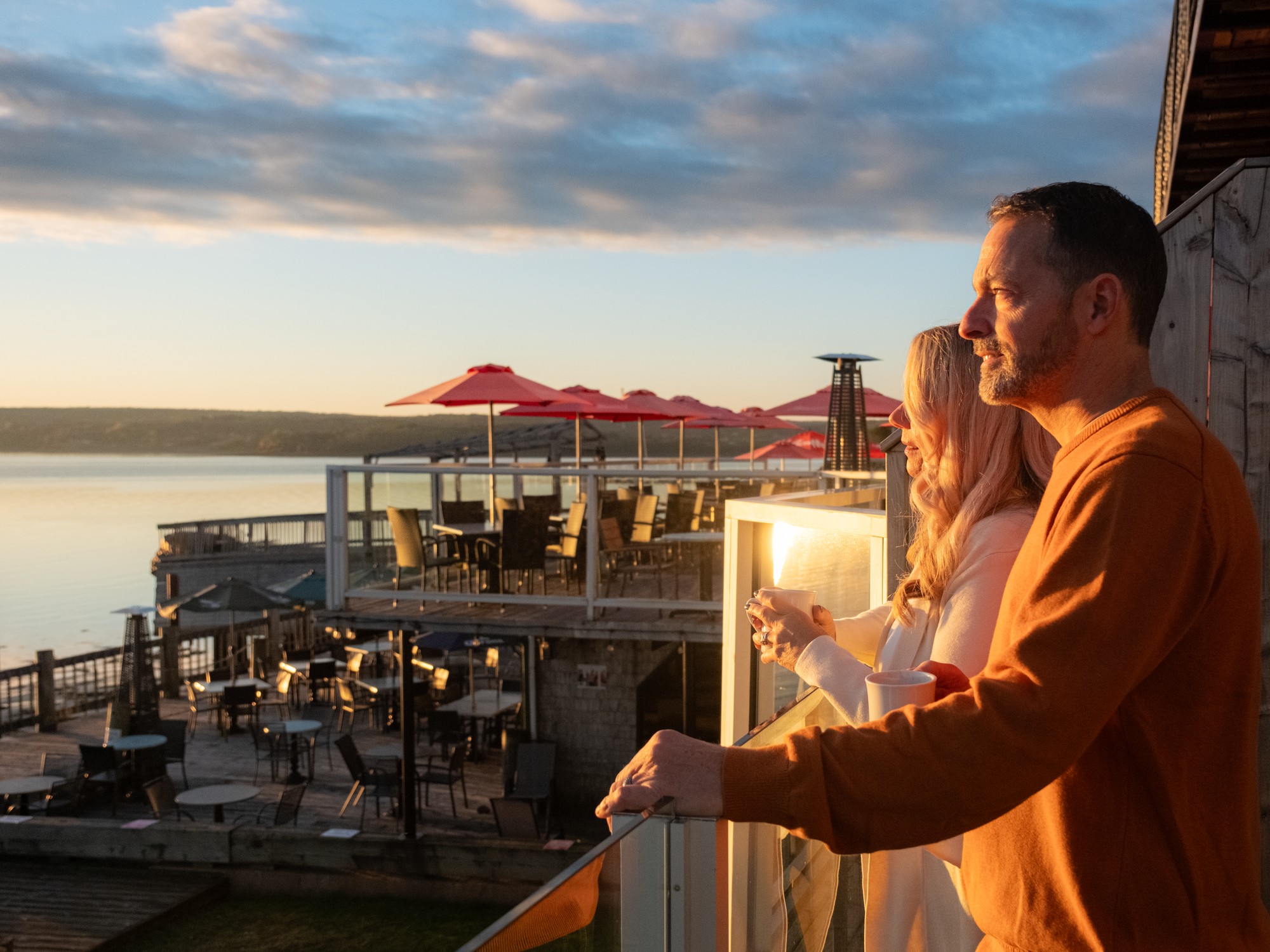 A couple stands at a balcony at Dockside Suites in Digby, Nova Scotia looking out over the water