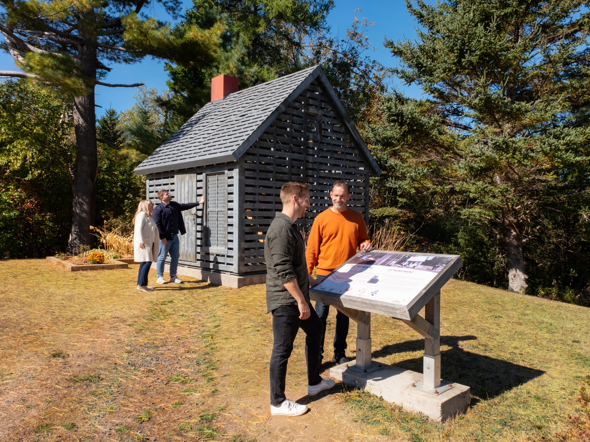Two people look at an interpretive panel at Maud Lewis Memorial Park near Digby