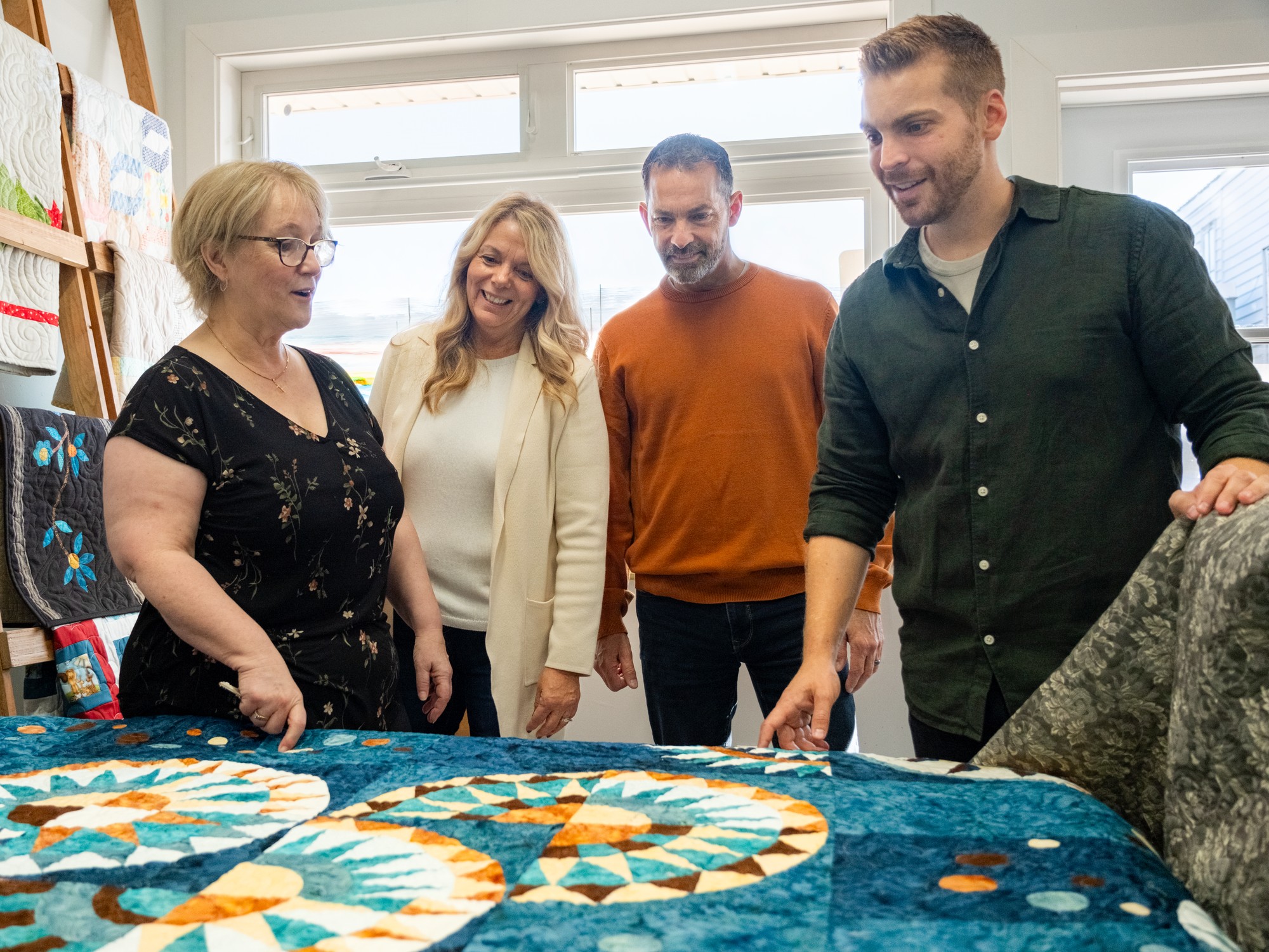 People look at a colourful hand made quilt at Quilts by the Bay near Digby, Nova Scotia