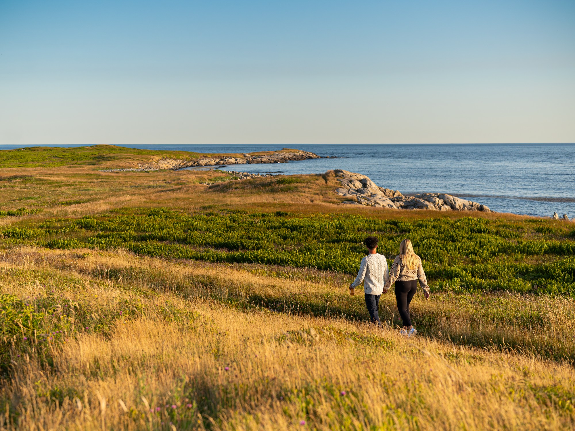 Two people walk along a coastal trail near Lockeport, Nova Scotia