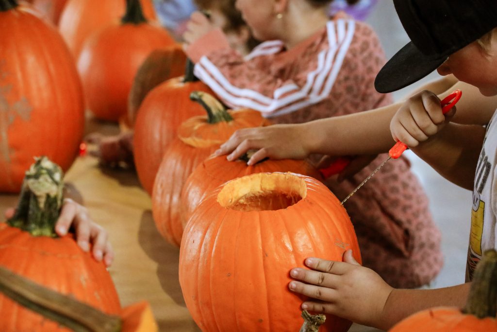 A child carves a pumpkin as part of the Celtic Colours community event: Pumpkin Carving in Chéticamp, Cape Breton Highlands National Park, Nova Scotia