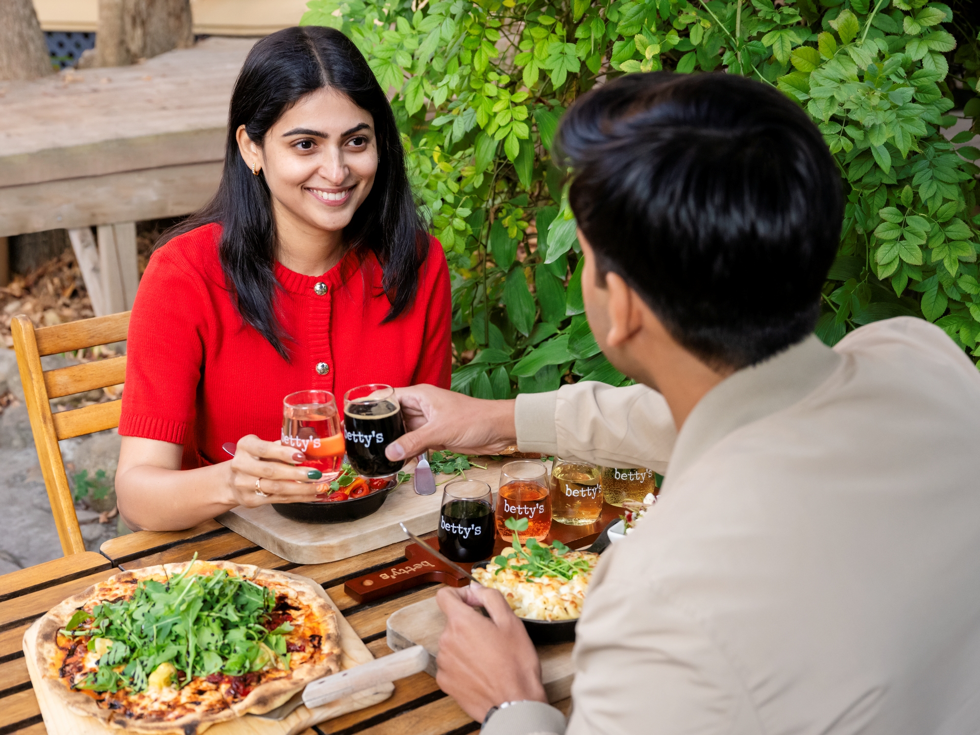 People enjoying pizza and wine on a patio