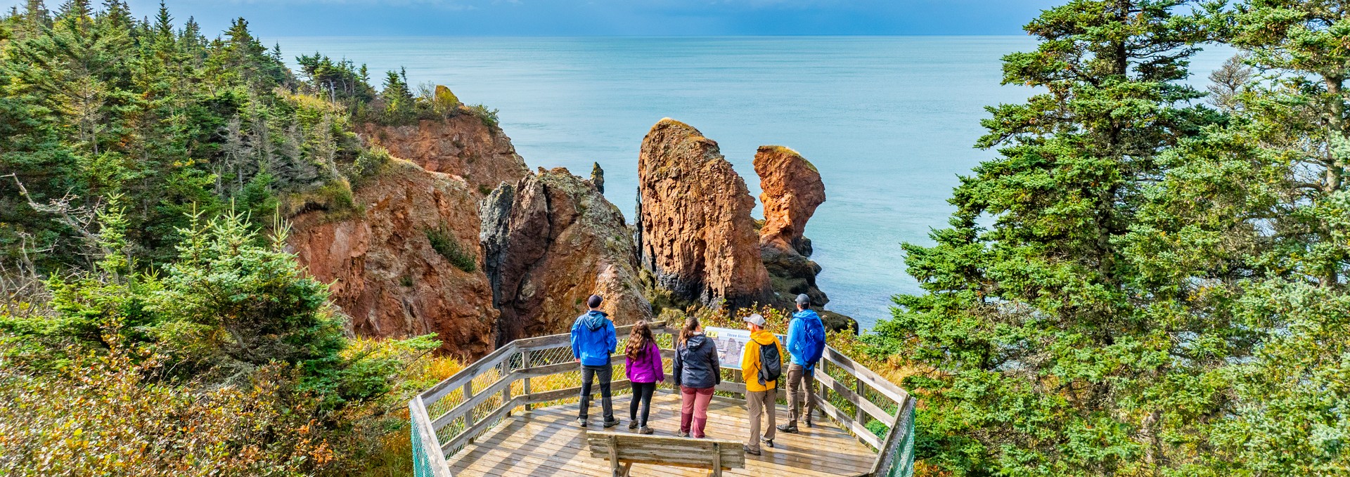 Hikers look at the Bay of Fundy from a viewing platform in Cape Chignecto Provincial Park