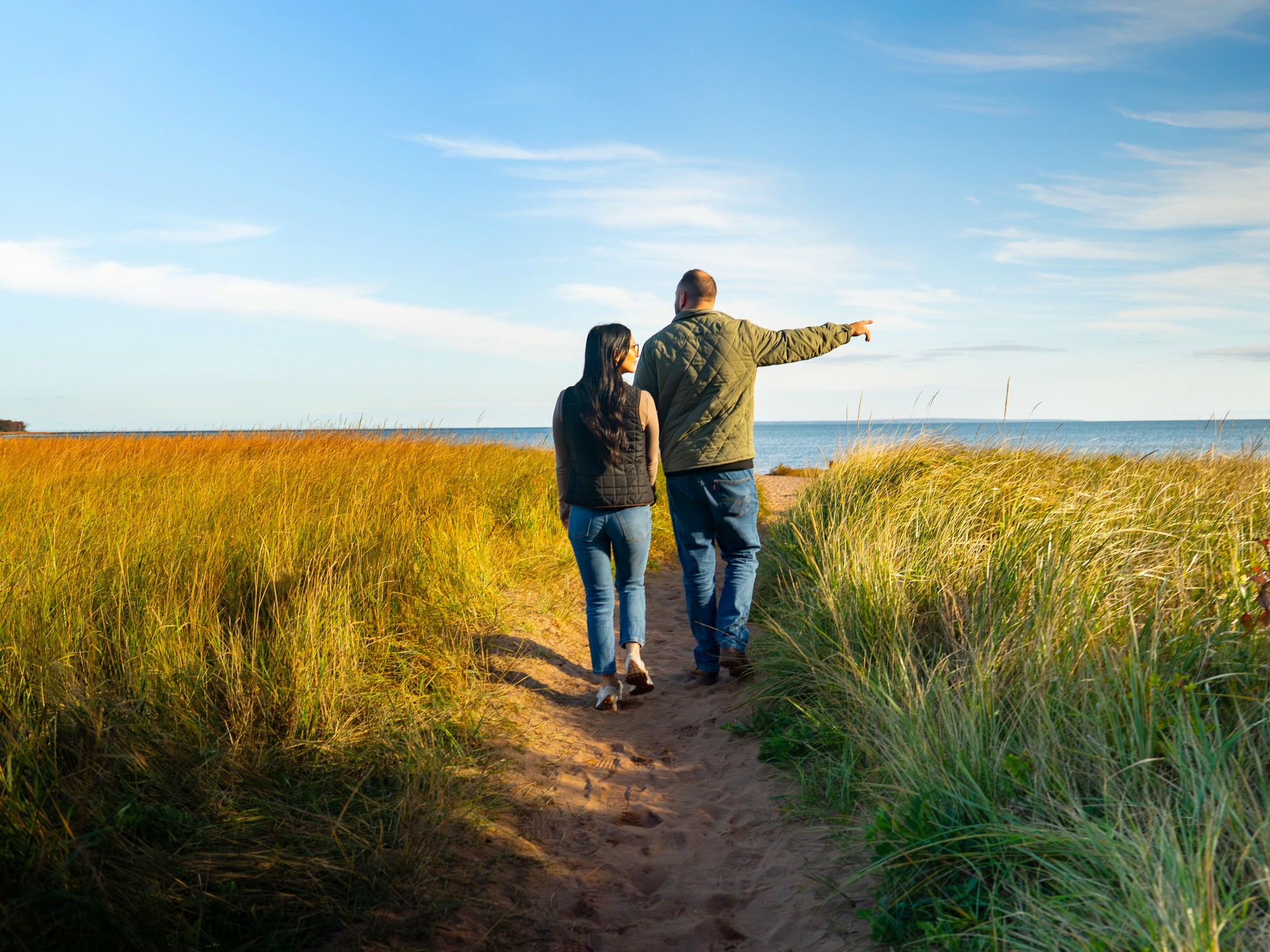 A couple walks along a sandy path towards Caribou_Munroes Island Beach